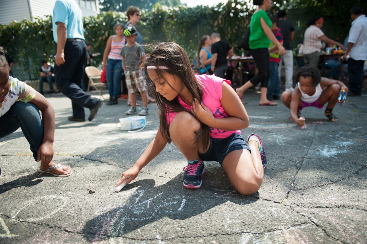 Valery Reyes, 8, draws with chalk during a Sunday block party sponsored by the One Everett organization on August 30, 2015. The block party included a bbq, musical performances, games for children, and tables for community organizations.